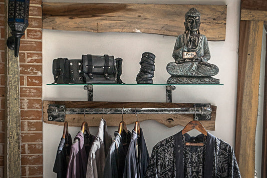Psylo alternative streetwear hanging on a clothes rail with Buddha statue slow fashion guide