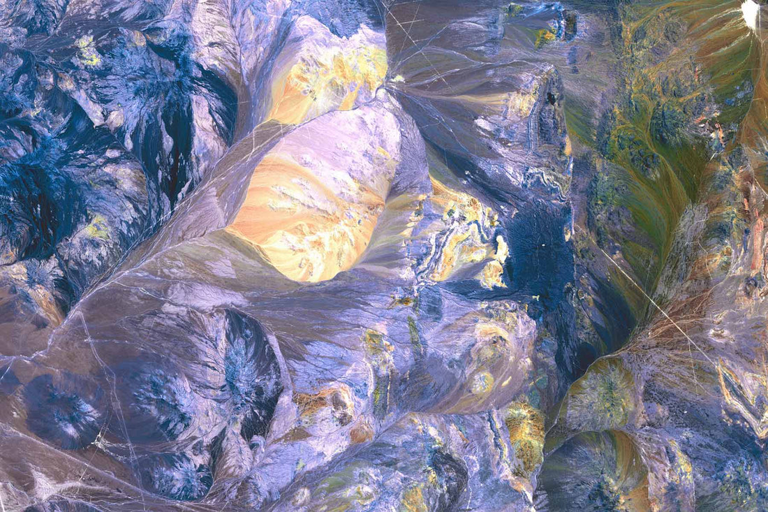 a satellite image of Atacama showing the vivid colours of the salt pans and gorges choked with mineral-streaked sediments and white-capped volcanoes