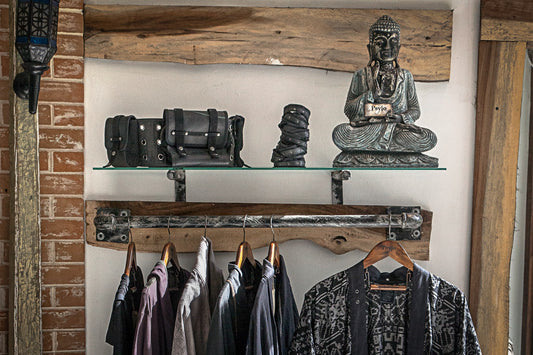 Psylo alternative streetwear hanging on a clothes rail with Buddha statue slow fashion guide